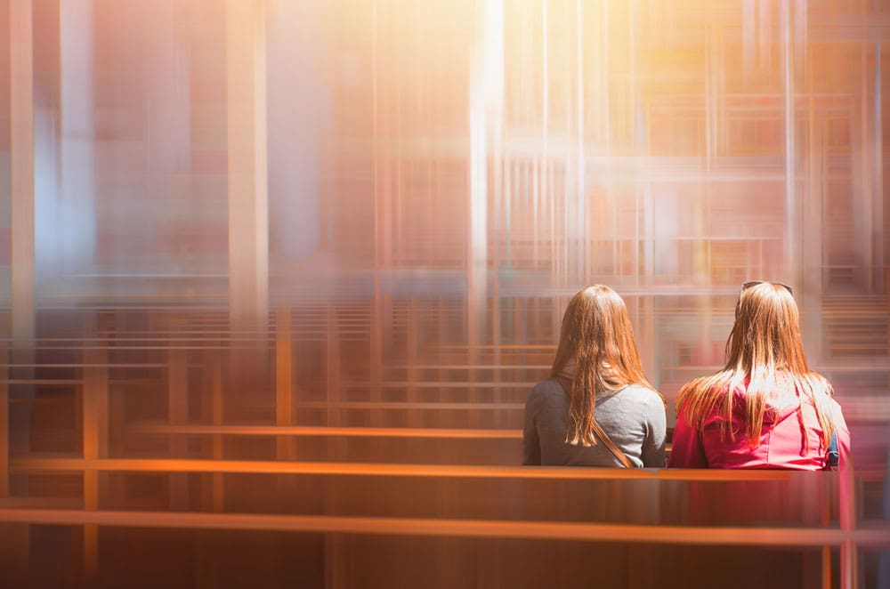 two women sitting in a church pew